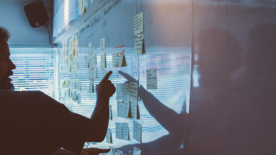 Picture of a person pointing at notes on a board.